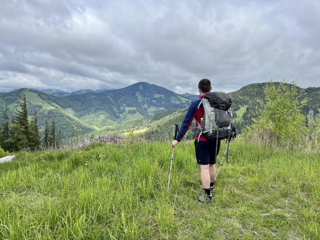 Ein Mensch auf einem Weg in den Bergen als Symbol für ein wohltuendes Leben und selbstbestimmte Veränderung zum Jahresbeginn