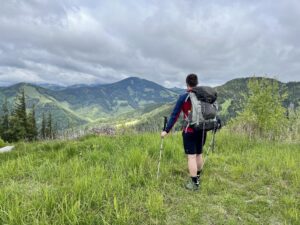 Ein Mensch auf einem Weg in den Bergen als Symbol für ein wohltuendes Leben und selbstbestimmte Veränderung zum Jahresbeginn